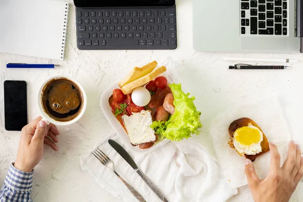 Ung man tar måltid framför laptop medan du arbetar, dålig vana och fetma begrepp — Stockfoto