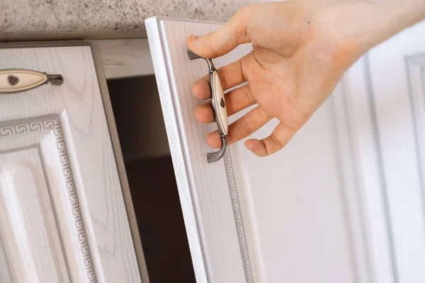 Close up person hand opens wooden shelf at home — Stock Photo, Image