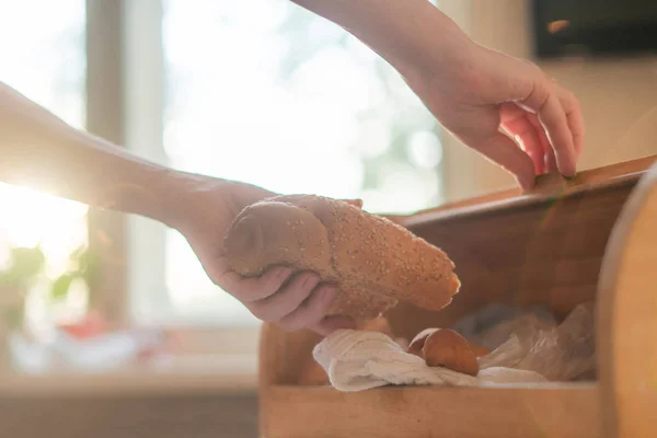 Vrouw het nemen van een brood brood uit een brood box in de keuken thuis — Stockfoto