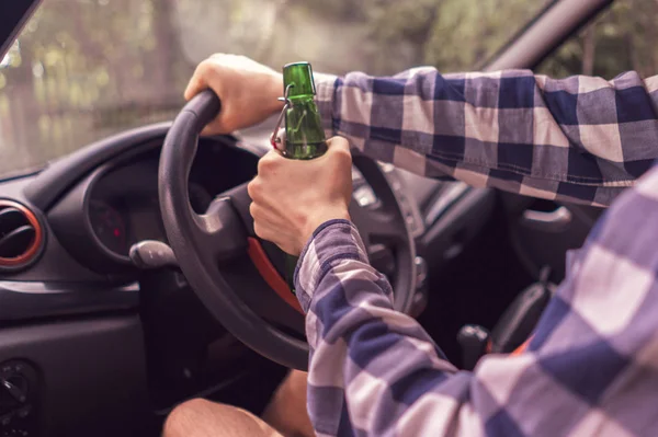 Mladý šílený opilý muž, který řídil auto a pije alkohol — Stock fotografie