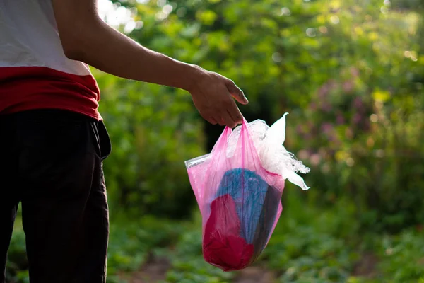 Человек забирает пакет и выносит мусор, заботится о природе и парке — стоковое фото