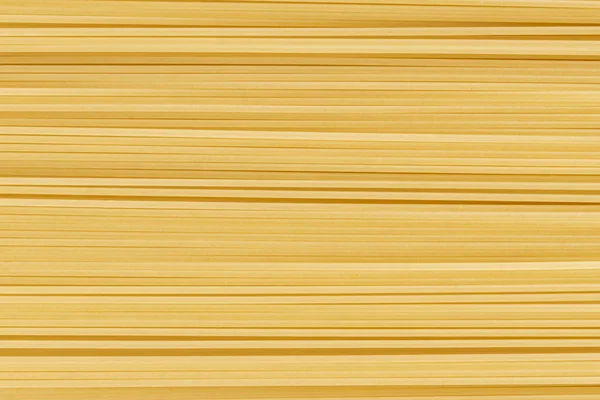 生または調理されていないスパゲティ麺の食感の抽象的な背景、テキストのためのコピースペース — ストック写真