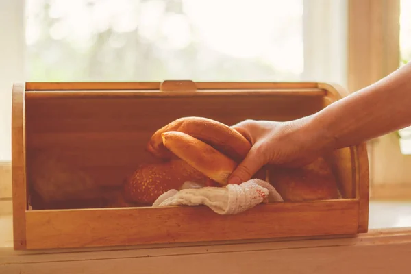 Vrouw het nemen van een brood brood uit een brood box in de keuken thuis — Stockfoto