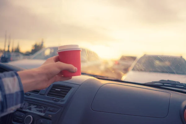 drinking coffee in paper cup during the journey in the car