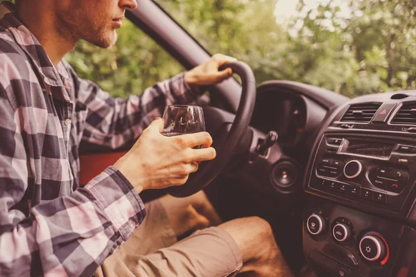 Joven loco borracho hombre conducir el coche y beber alcohol —  Fotos de Stock