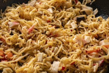 Masada makarna, avokado, tavada şehriye ve mantar pişirme malzemelerinin üst görüntüsü.