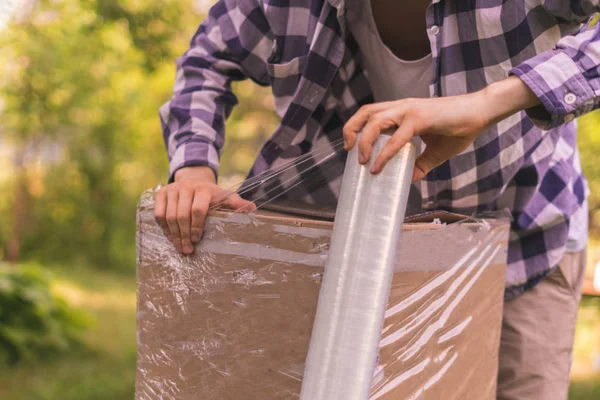 stretch wrap roll, man packing the box for shipping