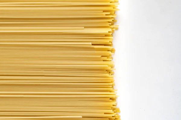 Abstract backgroung with raw or uncooked spaghetti noodles texture, copy space for text — Stock Photo, Image