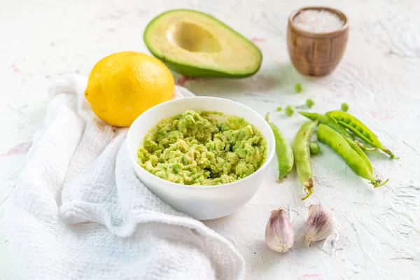 Guacamole molho cremoso para pão torrado com abacate e ervilhas, comida mexicana — Fotografia de Stock