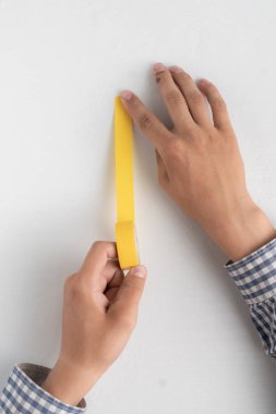 elleri yapışkan renkli bant tutarak ve beyaz yüzeylere uygulayın