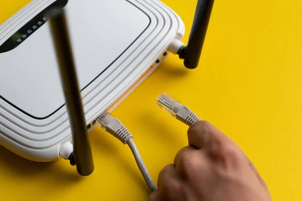 와이더넷 와이어 케이블을 Wi-Fi 리모컨 포인트로 연결하는 손 — 스톡 사진