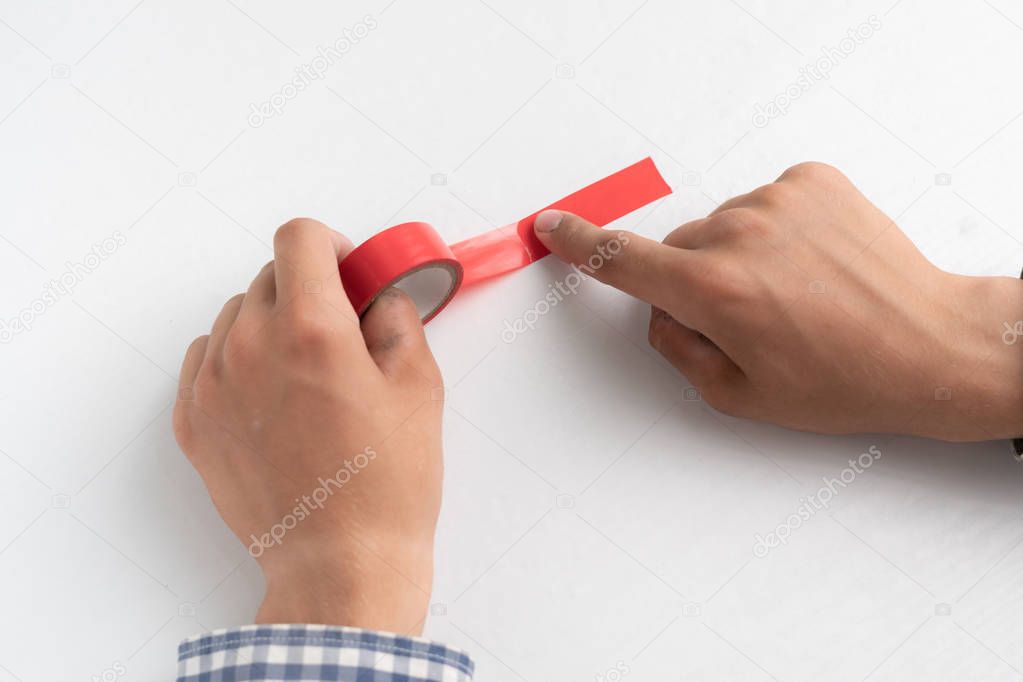 hands holding an adhesive color tape and apply it to the white surfaces