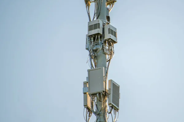 5g современное телевидение и смартфон телекоммуникационной станции антенны против неба в городе — стоковое фото