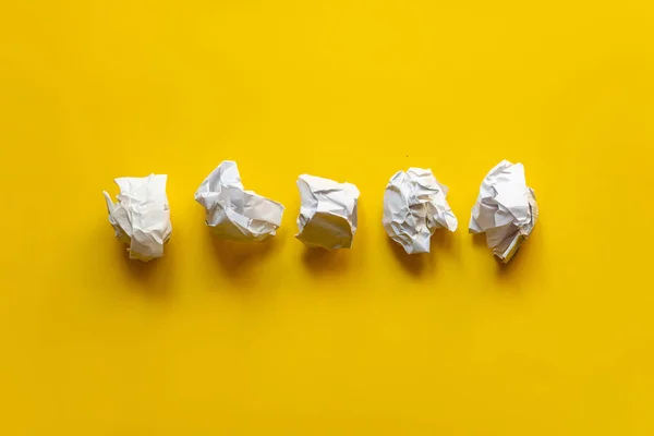 Několik bílých papírových koulí na stole v kanceláři, zmatek v myslích — Stock fotografie