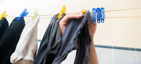 Mano colgando los calcetines con pinzas de ropa después de lavanderías — Foto de Stock