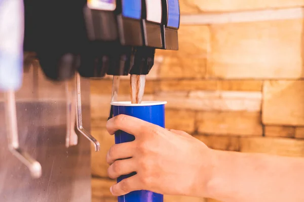 el bir fastfood restoranlarda limonata soda meşrubat makinesi dökmek için bir kağıt cam tutarak