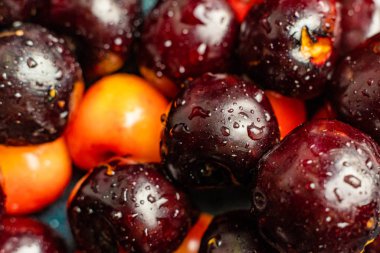 üzerlerinde su damlaları ile çok renkli kiraz meyveleri makro yakın, siyah kırmızı ve sarı