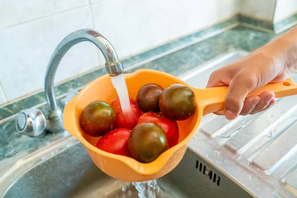 el taze meyve ve çilek ile bir kevgir tutarak ve suları ile mutfakta yıkama