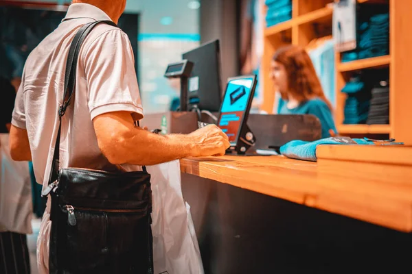 Взрослый потребитель платит кредитной картой в магазине, держа кошелек с — стоковое фото