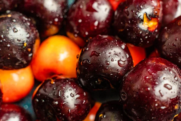 üzerlerinde su damlaları ile çok renkli kiraz meyveleri makro yakın, siyah kırmızı ve sarı