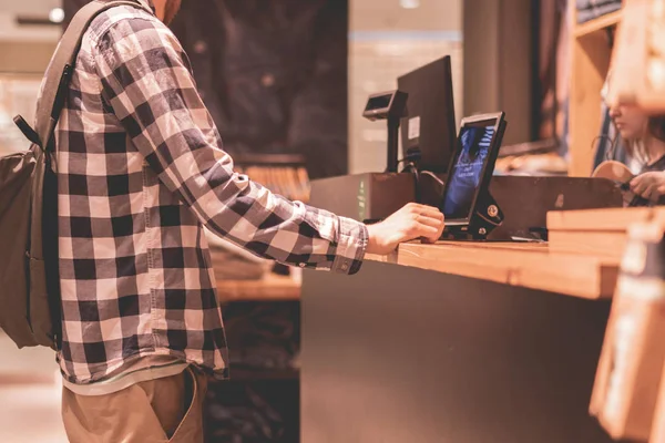 Joven haciendo una compra y pagando en la cubierta de efectivo en la tienda —  Fotos de Stock