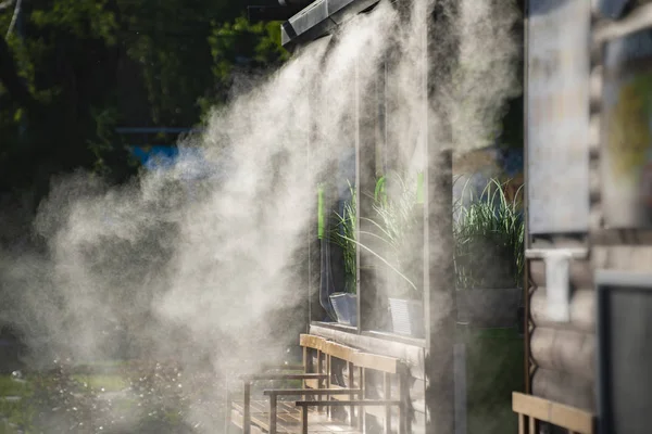 kaynayan sıcak yaz günlerinde bir kamu kafede soğutma için su püskürtme sistemi