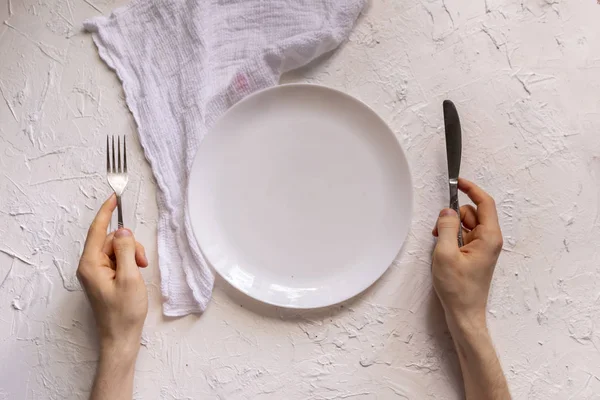 Ansicht der Hände einer Person auf dem Tisch mit leerem Teller-Design-Attrappen — Stockfoto