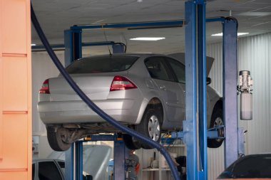 kırık otomobiller bir parça yerine bekleyen bir hidraulic jak üzerinde jacked