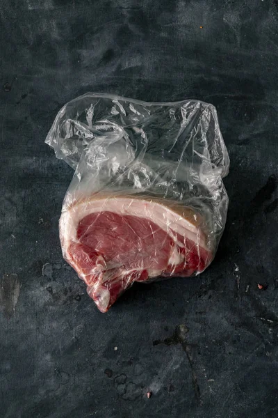 Świeże, zakrwawione surowe mięso w plastikowej torbie zaraz po zakupie u rzeźnika — Zdjęcie stockowe