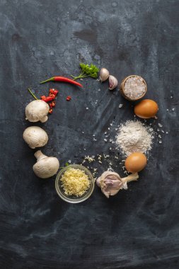 masada yemek pişirmek için ham maddeler, peynir, tuz, biber, yumurta ve koyu bir masada farklı sebzeler