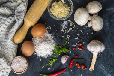 masada yemek pişirmek için ham maddeler, peynir, tuz, biber, yumurta ve koyu bir masada farklı sebzeler