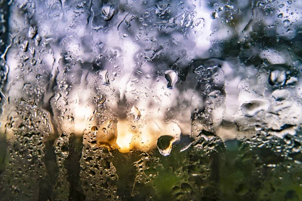 雨の日、抽象的な背景とテクスチャの後に窓に落ちる水のマクロショット — ストック写真