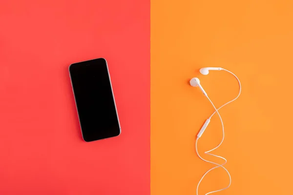 Flat lay of modern music player device and earphones, minimalistic concept on color surfaces — Stock Photo, Image