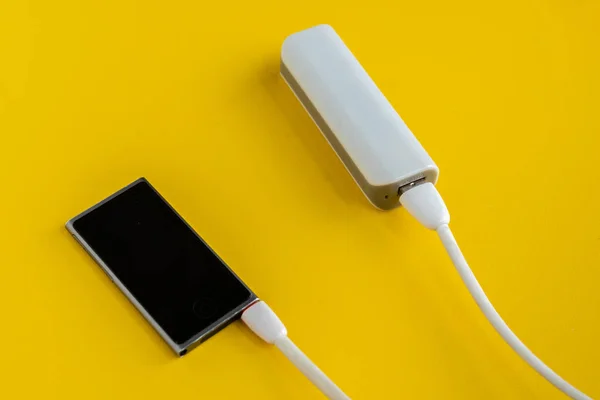 Powerbank заряжает современный смартфон или новый гаджет — стоковое фото