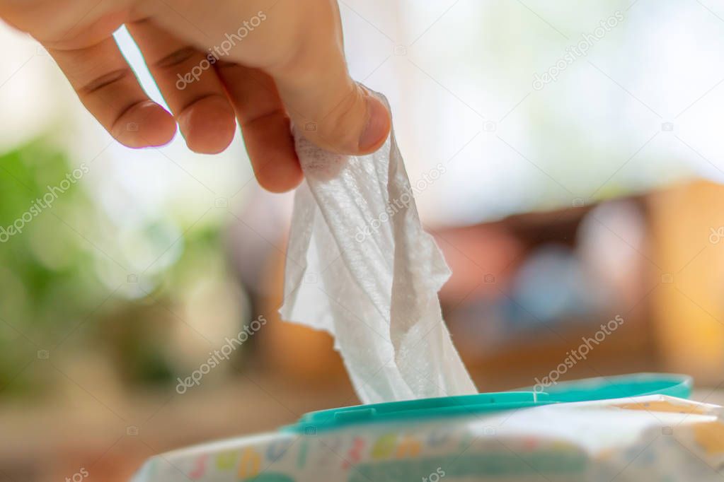 hand taking the wet wipe to clean skins