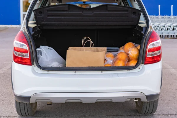 Opened car trunk with bags with food purchased in grocery store — Stock Photo, Image