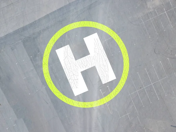 Helicopter helipad on the asphalt surface with letter "H" view from above — Stock Photo, Image