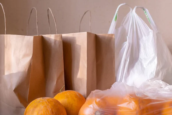 Pacotes de sacos de papel e plástico com alimentos na mesa — Fotografia de Stock
