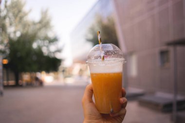 saman ile smoothie suyu plastik cam tutan el ilk kişi görünümü, sokak gıda kavramları