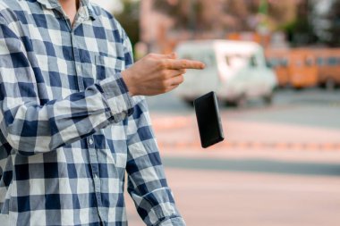 person holding a smartphone in the street, a phone falling and flying down by an accidents clipart
