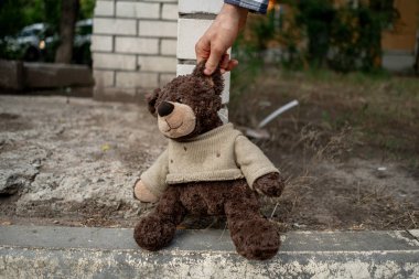 İnsan eli dışarıdaki kirli oyuncak ayıyı tutar, kavramını kaybeder.
