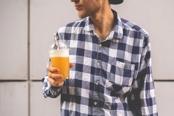 Ein Mann mit einem Smoothie-Glas zum Mitnehmen mit Stroh im Freien — Stockfoto
