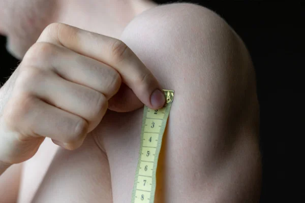 Person misst die Körpergröße mit einem Zentimeter, Makroaufnahme in der Dunkelheit — Stockfoto