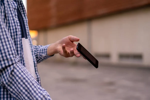 Osoba držící na ulici smartphone, telefon, který padá a letí dolů po nehodě — Stock fotografie