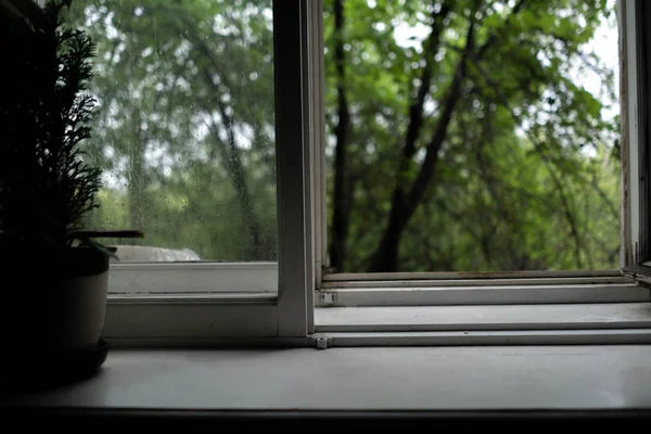 Conceito nostálgico, janela aberta em casa walm aconchegante enquanto chove ao ar livre — Fotografia de Stock