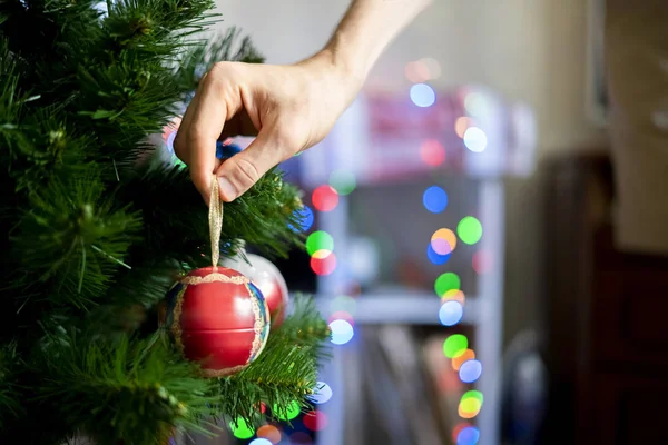 Zbliżenie dłoni dekorowanie chrismas drzewo z piękną czerwoną piłkę zabawka f — Zdjęcie stockowe