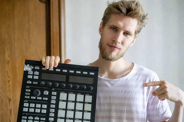 Ritratto di giovane barbuto produttore di suoni che detiene midi controller e cuffie f — Foto Stock