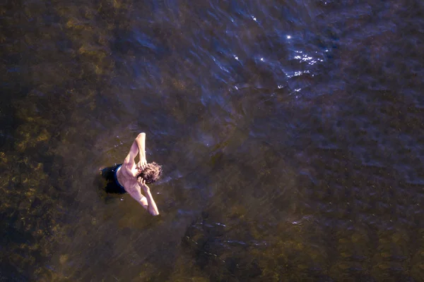 Arriba viea de hombre joven disfrutando de agua de mar en la playa, de pie en el día de verano — Foto de Stock