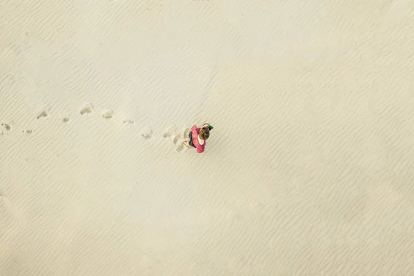Vista aérea superior del joven solitario caminar en el desierto en la textura de la arena. concepto perdido — Foto de Stock