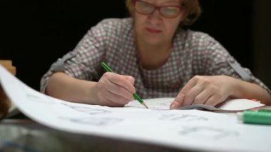 kadın tasarımcı kağıt üzerinde giysi kroki çizmek
